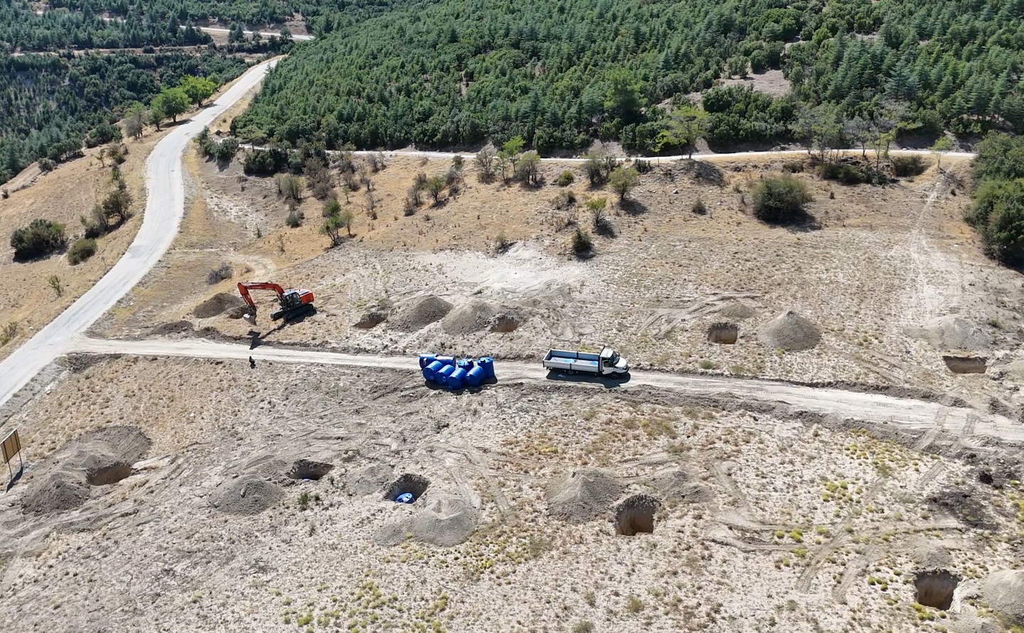 Sahadan hava görünümü — iş makinesi, su tankları ve başlayan altyapı çalışmaları